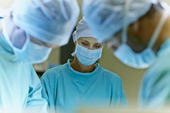 A bust shot of three doctors in surgery