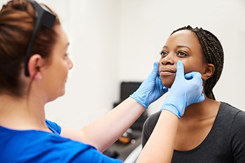 A doctor examining a woman's face
